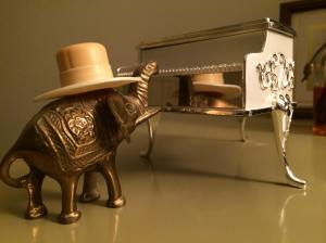  Reaching up to tickle the ivories, he is momentarily distracted by his reflection. "I look good in a hat!"